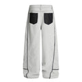 Washed distressed deconstruction with visible stitching and drawstring jeans